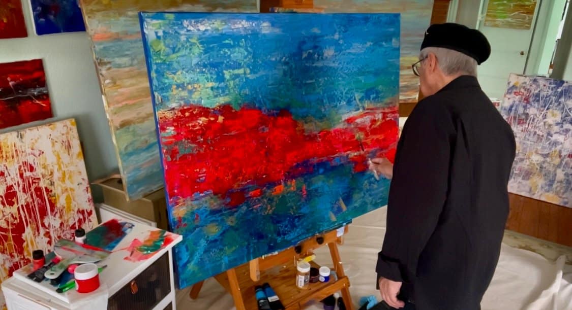 Abstract Artist Gregory Christeas at front of his easel painting